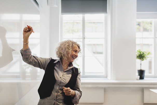 Frau, die lächelt und an ein Whiteboard schreibt