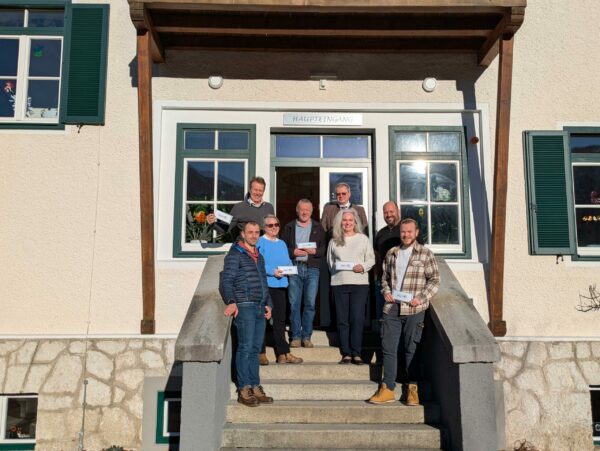 Das Projektteam steht an einem sonnigen Tag gemeinsam auf einem Stiegenaufgang und lächelt in die Kamera.